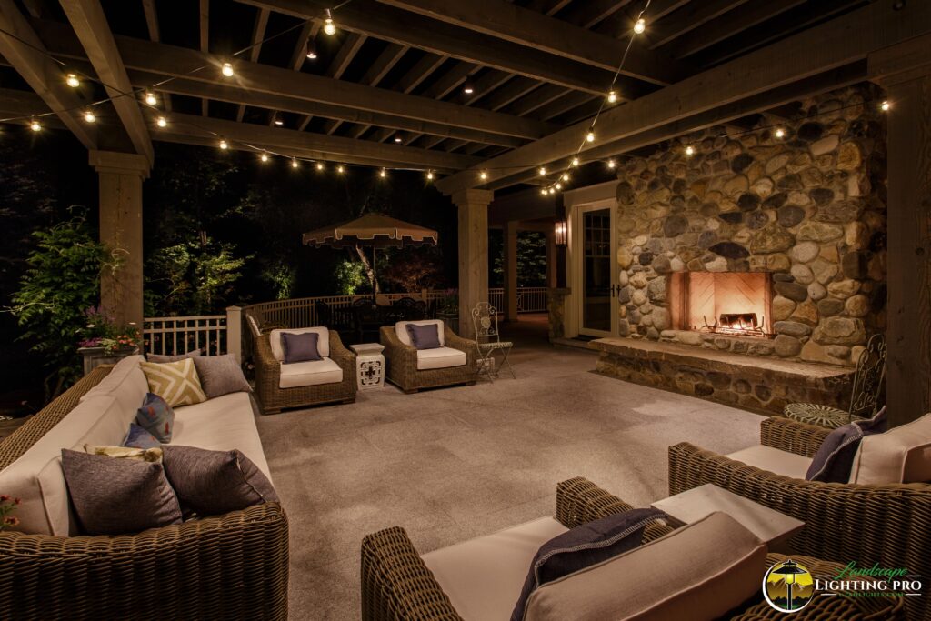 outdoor porch featuring a cozy fireplace and a canopy of bistro lights