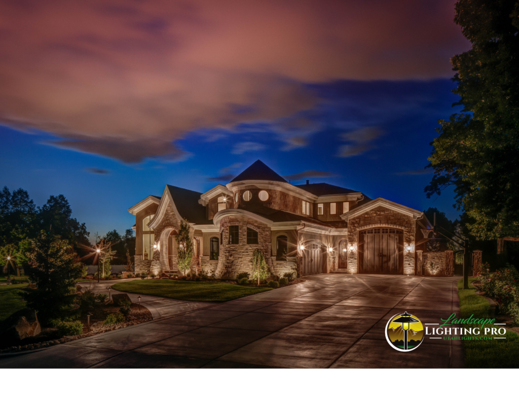 Elegant stone luxury home at twilight with soft architectural lighting highlighting the facade, entryway, and driveway — showcasing refined outdoor lighting design.